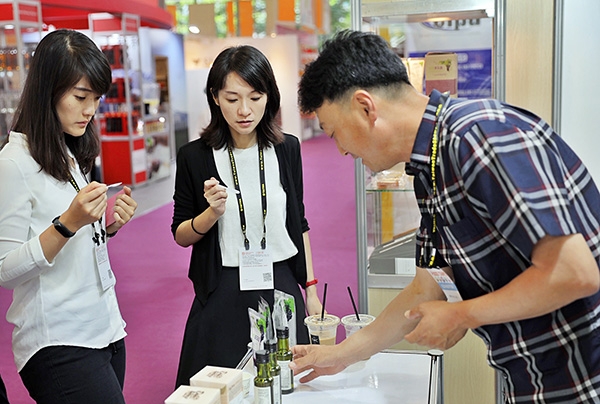 한국관을 찾은 대만 바이어들이 전시된 한국 제품들을 시식하고 있다. 사진=한국농수산식품유통공사 제공